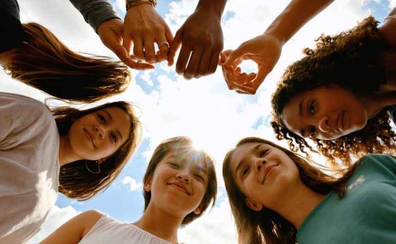 A diverse group of young people forming a supportive circle, symbolizing unity, empathy, and hope in transforming youth mental health through peer support.