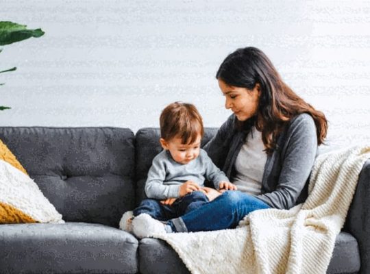 A caring parent comforts their anxious child in a nurturing home environment, surrounded by comforting elements like a soft blanket and warm lighting, symbolizing a supportive atmosphere.