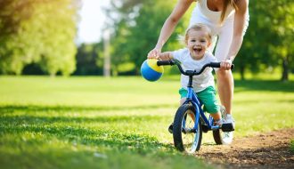 A parent and child smiling while playing together in a park, illustrating the joy and mental health benefits of exercise.